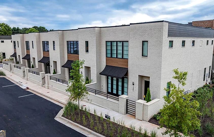 Modern white brick townhomes with black steel awnings at Wire Park in Watkinsville, Georgia